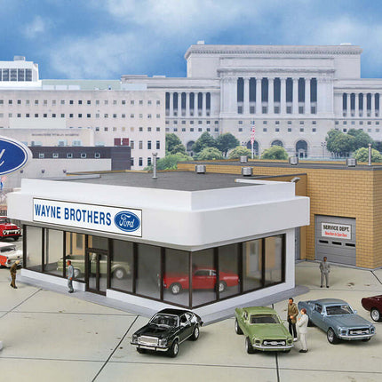HO scale Ford dealership model with showroom, service bay, and classic cars in an urban setting.