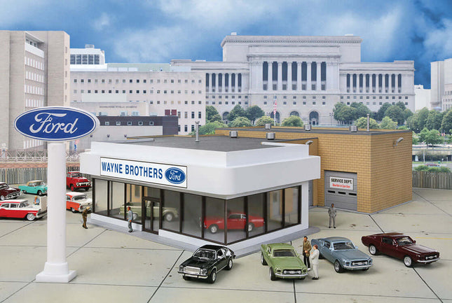 HO scale Ford dealership model with showroom, service bay, and classic cars in an urban setting.