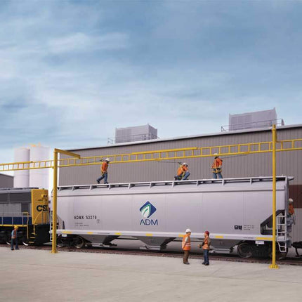 Workers on top of a freight car at a transload facility, showcasing safety systems in use for loading and unloading operations.