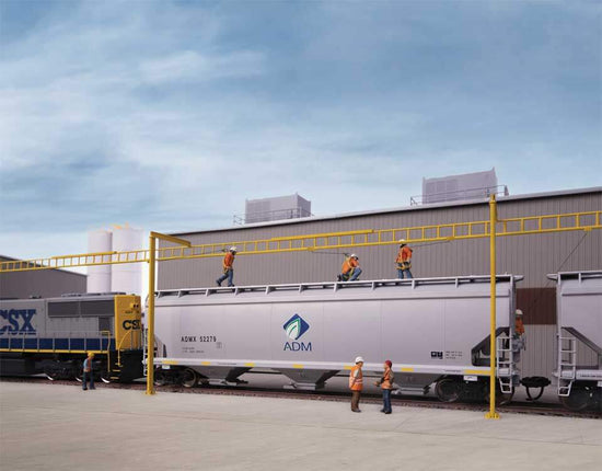 Workers on top of a freight car at a transload facility, showcasing safety systems in use for loading and unloading operations.