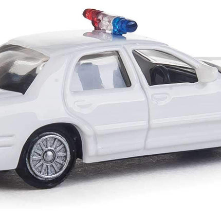 Walthers HO Ford Crown Victoria Police Interceptor model in white with rooftop lightbar, ideal for layouts and city scenes.