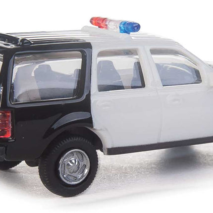 Walthers HO scale Ford Expedition Special Service Vehicle in black and white with police lights on roof.