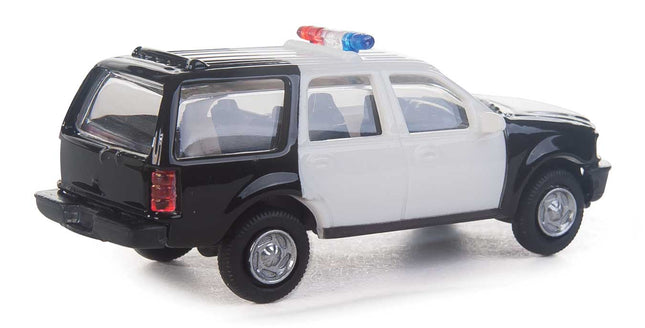 Walthers HO scale Ford Expedition Special Service Vehicle in black and white with police lights on roof.