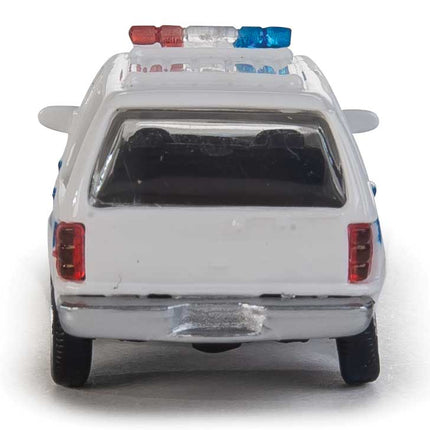 Walthers HO Ford Expedition SSV in white with blue stripe, featuring a molded lightbar on top, ideal for model layouts.
