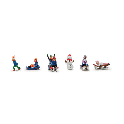 Colorful painted N scale figures of children sledding and skiing, perfect for winter model landscapes and dioramas.