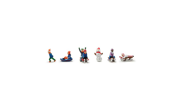 Colorful painted N scale figures of children sledding and skiing, perfect for winter model landscapes and dioramas.